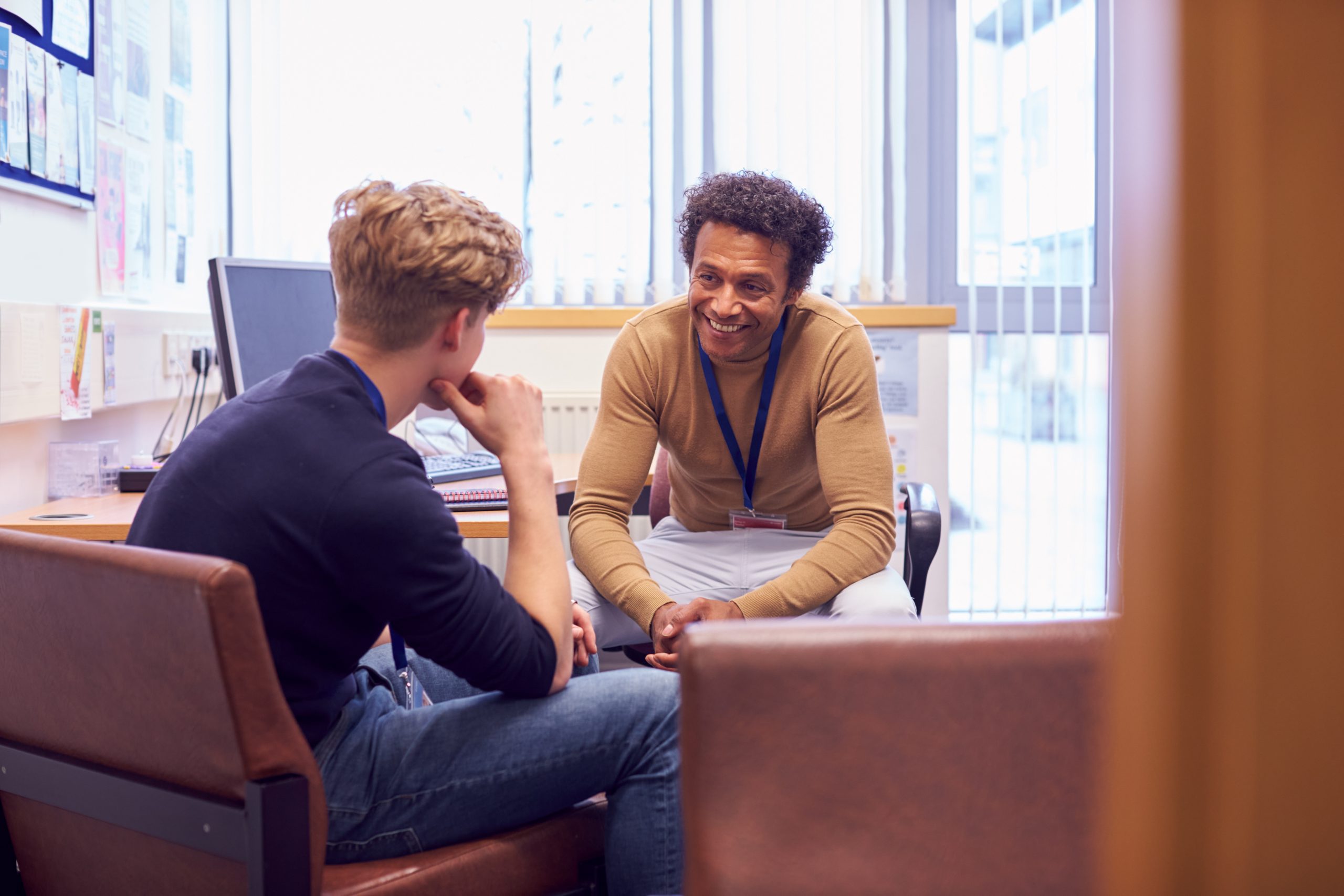 a male student and a college counselor inside an office, having a discussion and conversation about mental health issues