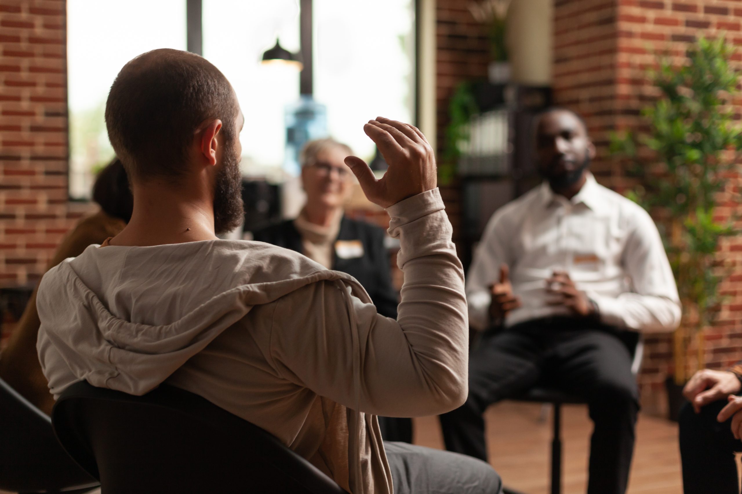 a man with addiction sharing mental health issues with a group at an AA meeting